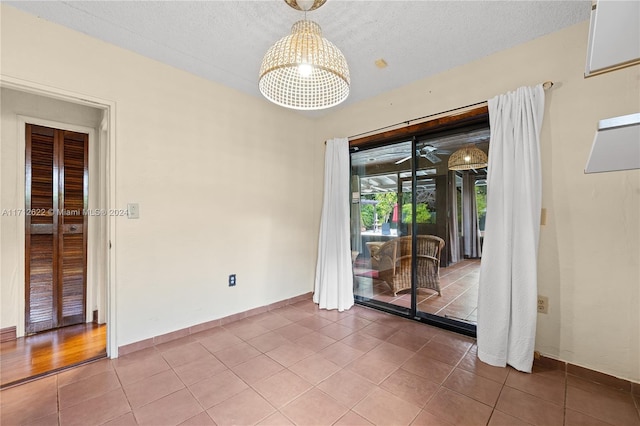 tiled spare room featuring a textured ceiling