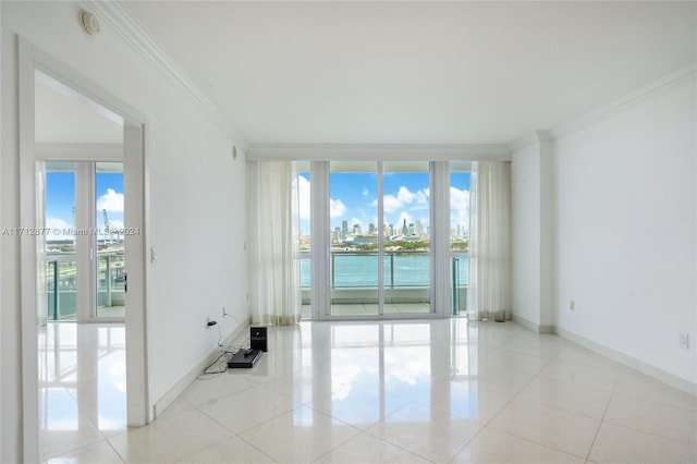 unfurnished room featuring crown molding, a water view, and light tile patterned floors