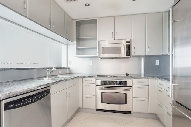 kitchen featuring light tile patterned flooring, sink, and appliances with stainless steel finishes