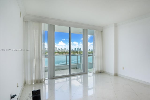 unfurnished room with floor to ceiling windows, crown molding, and light tile patterned floors