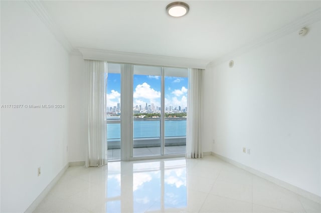 unfurnished room featuring expansive windows, a water view, and ornamental molding