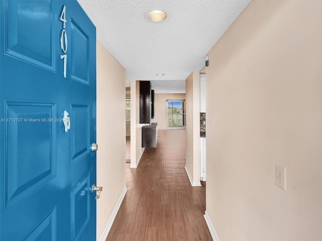 hall featuring dark hardwood / wood-style floors and a textured ceiling