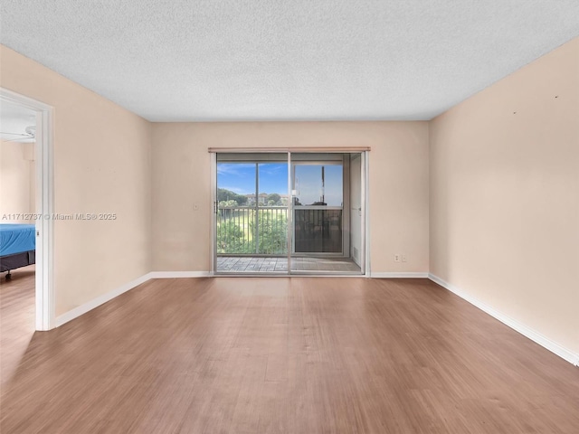 empty room with wood-type flooring and a textured ceiling