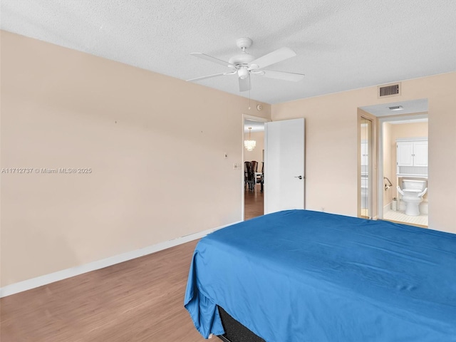 bedroom featuring connected bathroom, ceiling fan, wood-type flooring, and a textured ceiling