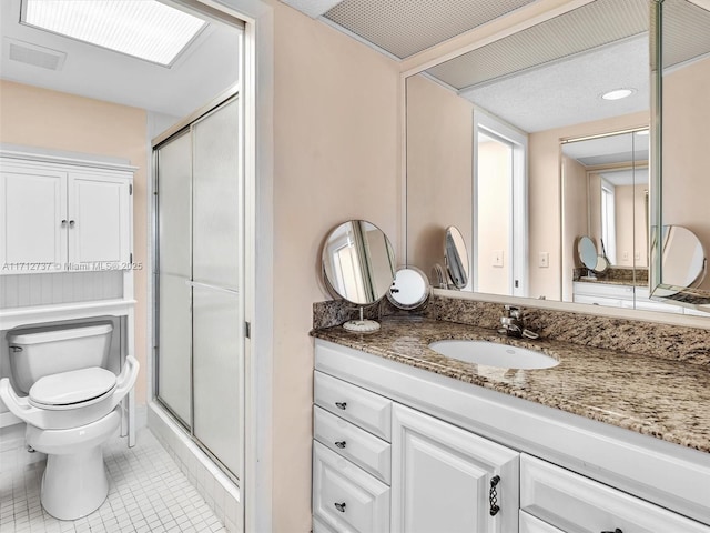 bathroom with tile patterned flooring, vanity, toilet, and an enclosed shower