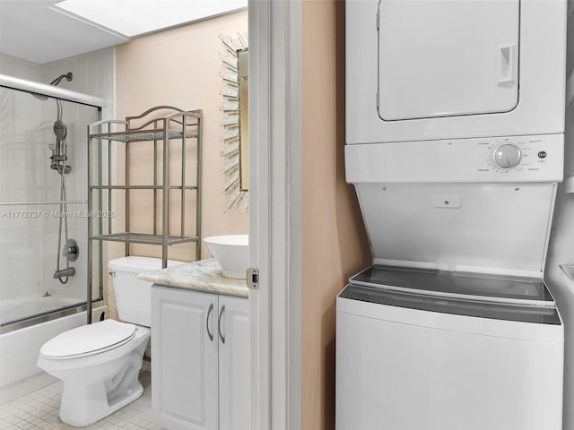 laundry area with stacked washer / dryer and light tile patterned floors