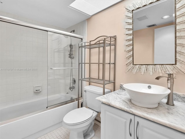 full bathroom featuring toilet, vanity, tile patterned floors, and enclosed tub / shower combo