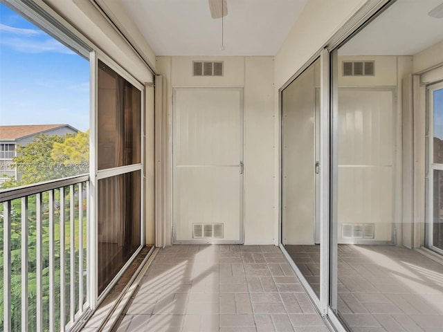 unfurnished sunroom featuring ceiling fan