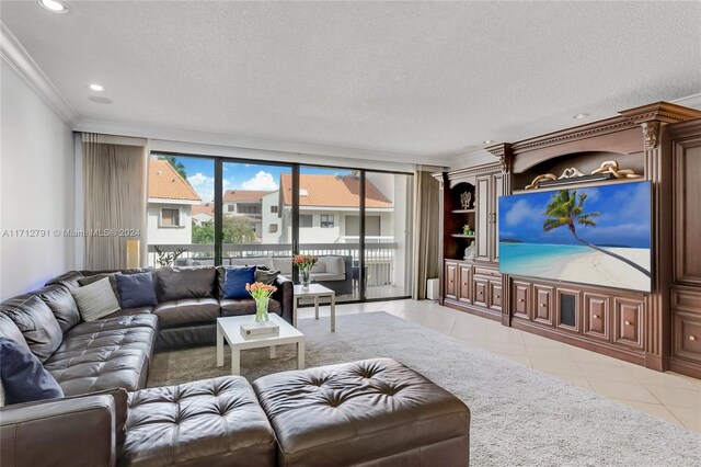 living room featuring light tile patterned floors, a textured ceiling, and ornamental molding