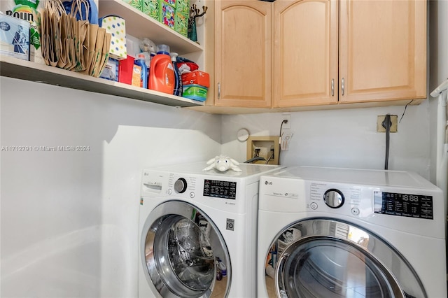 laundry room featuring cabinets and washing machine and dryer