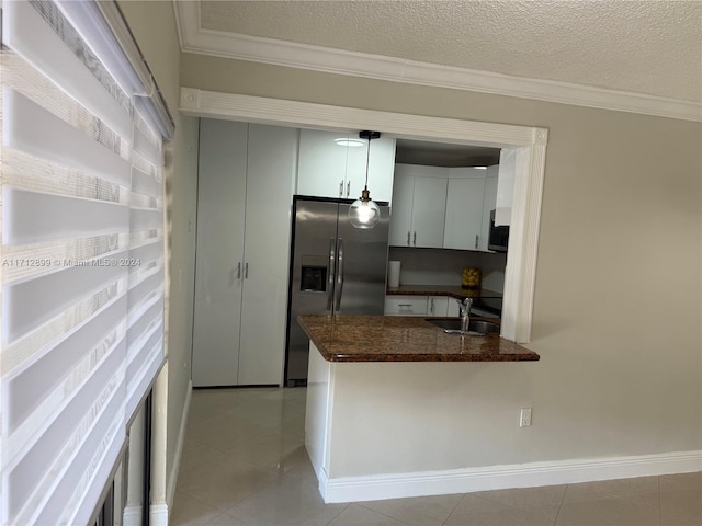 kitchen featuring stainless steel fridge, a textured ceiling, crown molding, sink, and pendant lighting