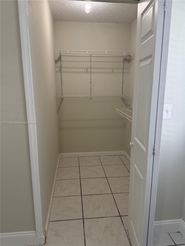 walk in closet with light tile patterned floors