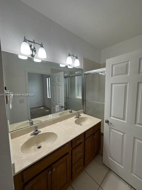 bathroom with tile patterned floors, vanity, and a shower with door