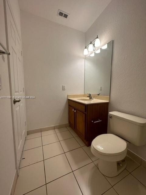 bathroom featuring tile patterned flooring, vanity, and toilet