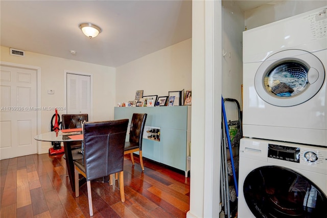 interior space with stacked washing maching and dryer and dark wood-type flooring