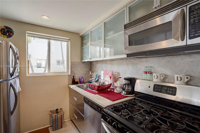 kitchen with decorative backsplash and appliances with stainless steel finishes