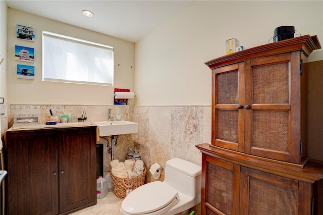 bathroom featuring sink, tile patterned flooring, tile walls, and toilet