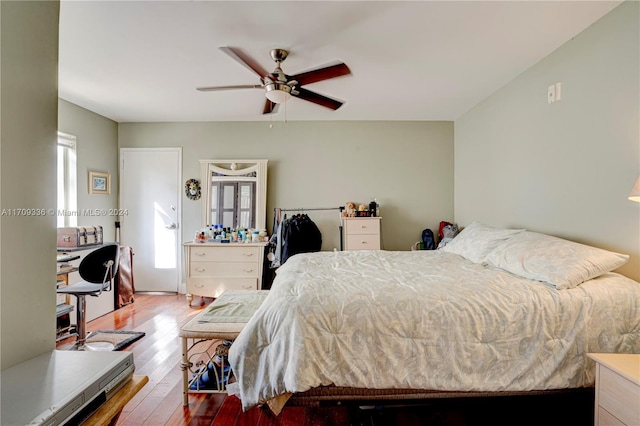 bedroom featuring ceiling fan, multiple windows, and light hardwood / wood-style flooring