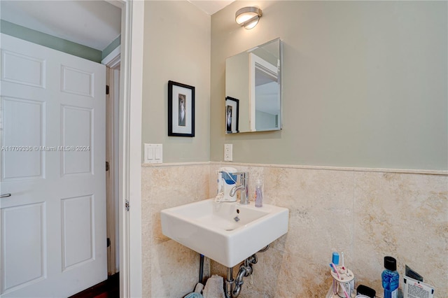 bathroom featuring sink and tile walls