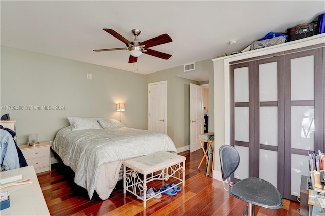 bedroom with dark hardwood / wood-style flooring and ceiling fan