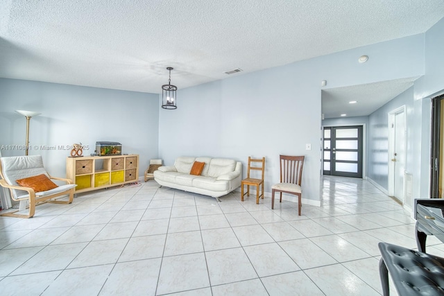 tiled living room featuring a textured ceiling