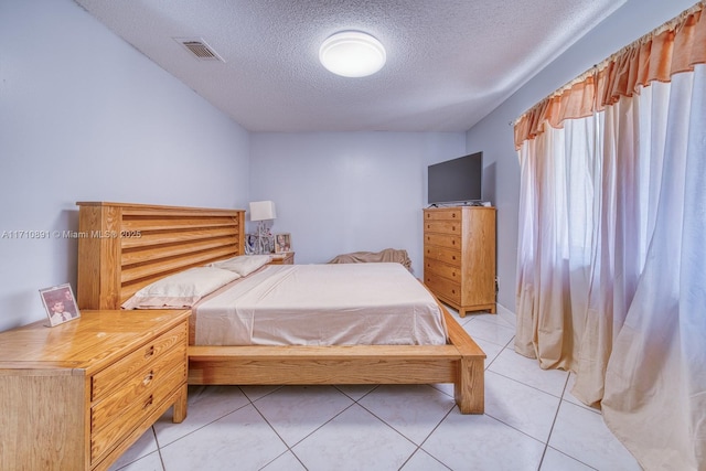 bedroom with light tile patterned floors and a textured ceiling