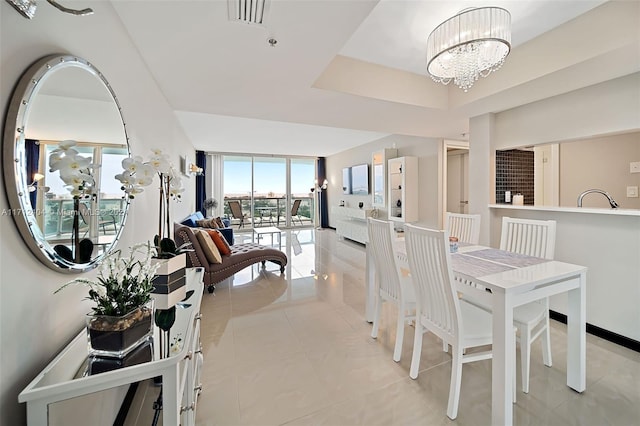 dining space with light tile patterned floors, sink, and a chandelier