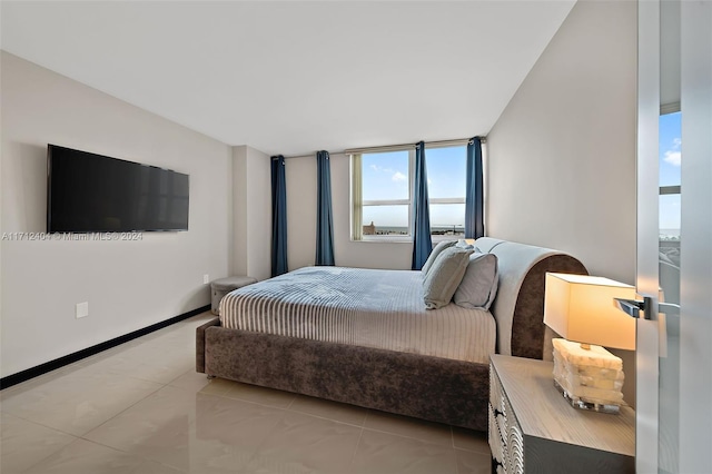 bedroom featuring light tile patterned floors and a wall of windows