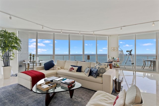 tiled living room featuring expansive windows and a water view