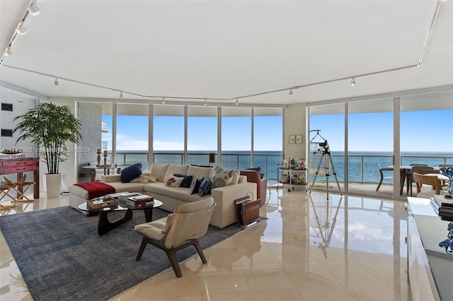 living room featuring expansive windows, a water view, and light tile patterned floors