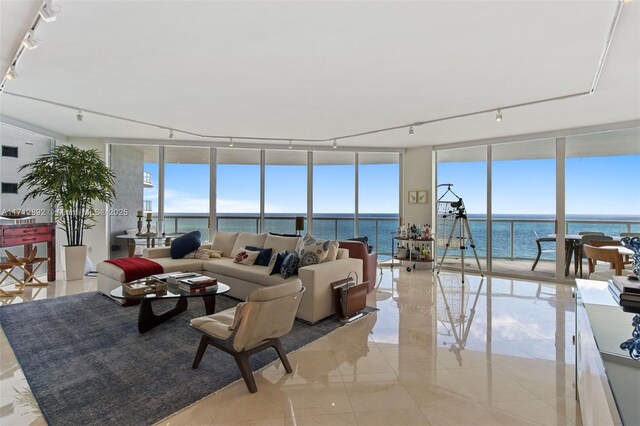 living room with rail lighting, expansive windows, and a water view