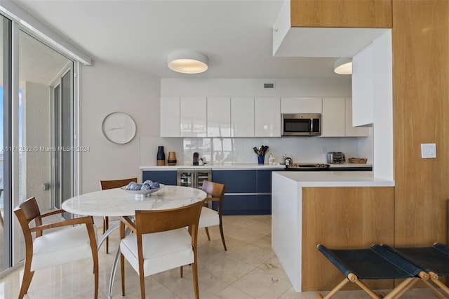 kitchen featuring white cabinets, backsplash, and a healthy amount of sunlight