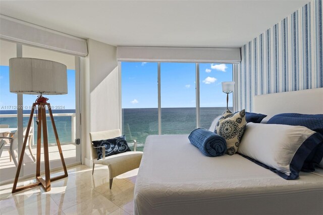 bedroom featuring multiple windows and a water view