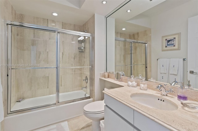 full bathroom with shower / bath combination with glass door, tile patterned floors, vanity, and toilet