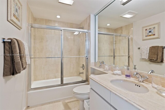 full bathroom with vanity, toilet, and shower / bath combination with glass door