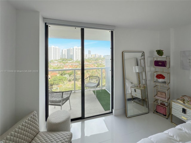 bedroom with a city view, a wall of windows, and access to exterior