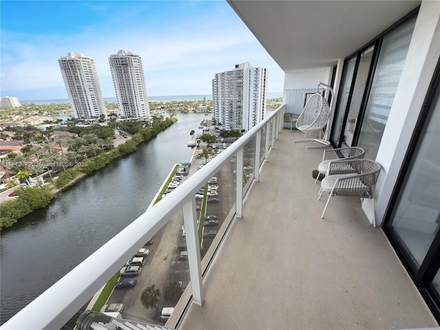 balcony with a water view and a view of city