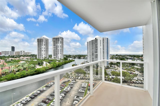 balcony featuring a water view and a city view