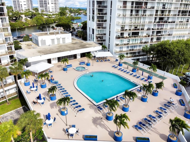 view of swimming pool featuring a water view, a city view, and a patio