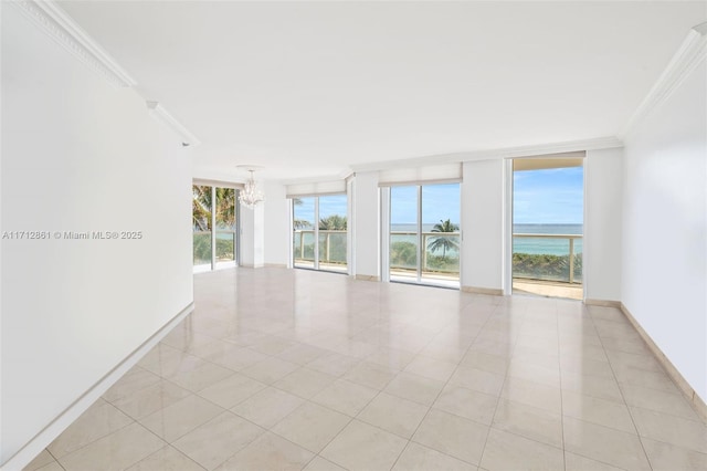 unfurnished room featuring expansive windows, a water view, light tile patterned floors, and an inviting chandelier