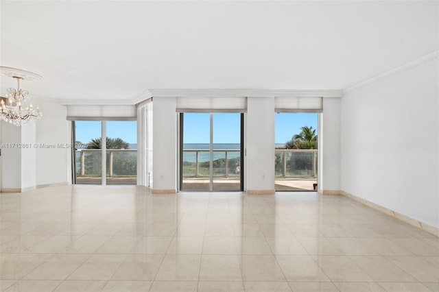 empty room with crown molding, a water view, light tile patterned flooring, and a notable chandelier