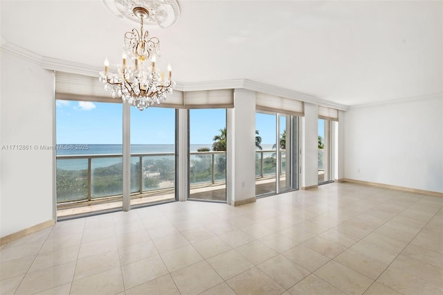 tiled empty room with expansive windows, a water view, ornamental molding, and a notable chandelier