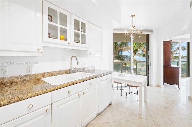 kitchen with white dishwasher, white cabinetry, sink, and hanging light fixtures