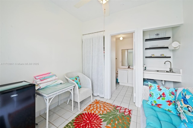 interior space featuring ceiling fan, light tile patterned floors, and ensuite bathroom