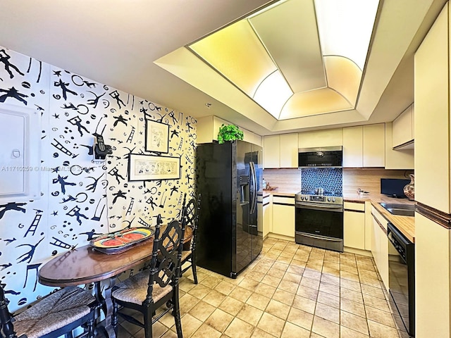 kitchen with white cabinets, sink, tasteful backsplash, and black appliances