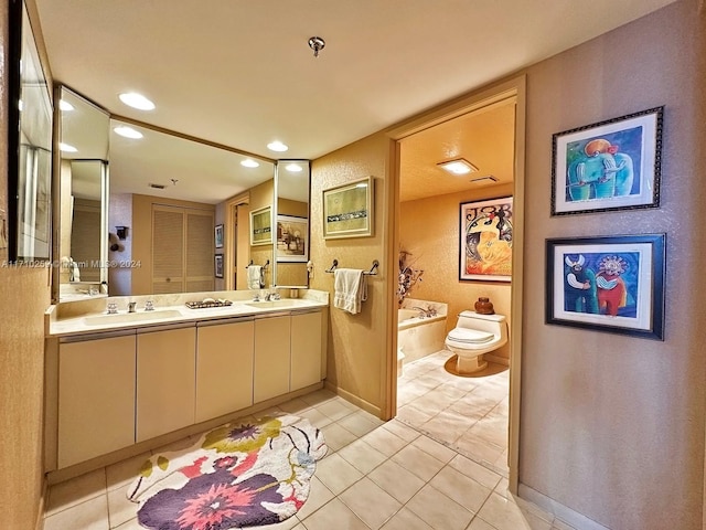 bathroom featuring tile patterned flooring, vanity, toilet, and a tub to relax in