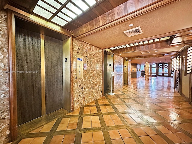 hall with beam ceiling and elevator