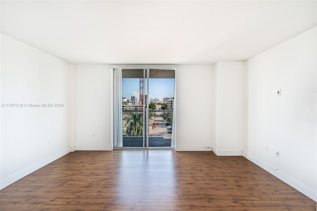 unfurnished room with dark wood-type flooring