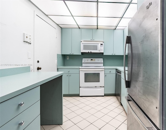 kitchen featuring a paneled ceiling, light tile patterned flooring, and stainless steel appliances