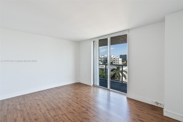 empty room featuring hardwood / wood-style flooring and floor to ceiling windows